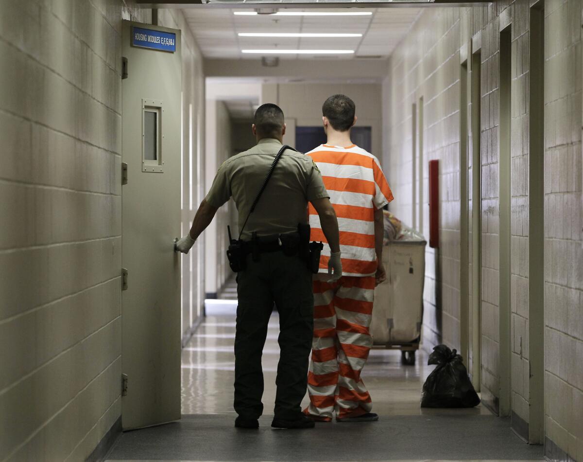 An inmate at the Madera County Jail is taken to one of the inmate housing units.