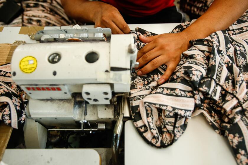 A person operates a sewing machine 