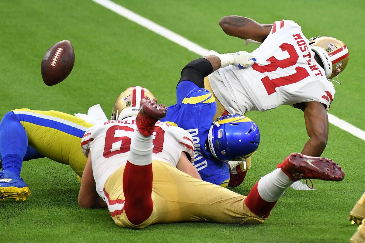 Rams defensive lineman Aaron Donald forces a fumble as he tackles 49ers running back Raheem Mostert.