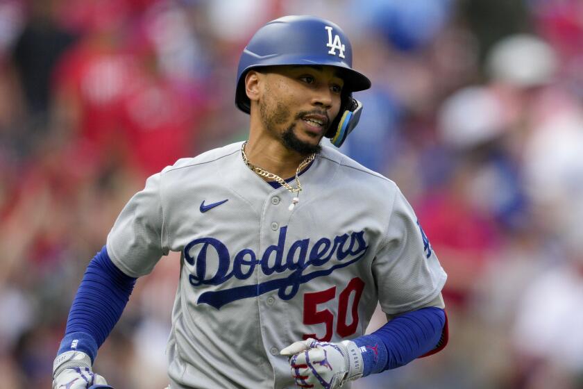 Los Angeles Dodgers' Mookie Betts (50) hits a solo home run during a baseball game.