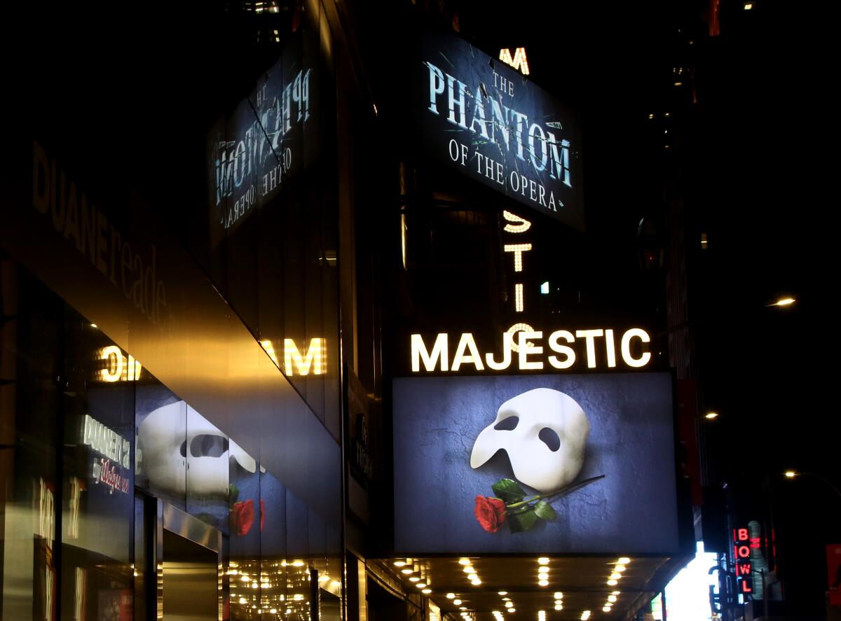Lighted signs outside a theater reading "The Phantom of the Opera" and "Majestic"