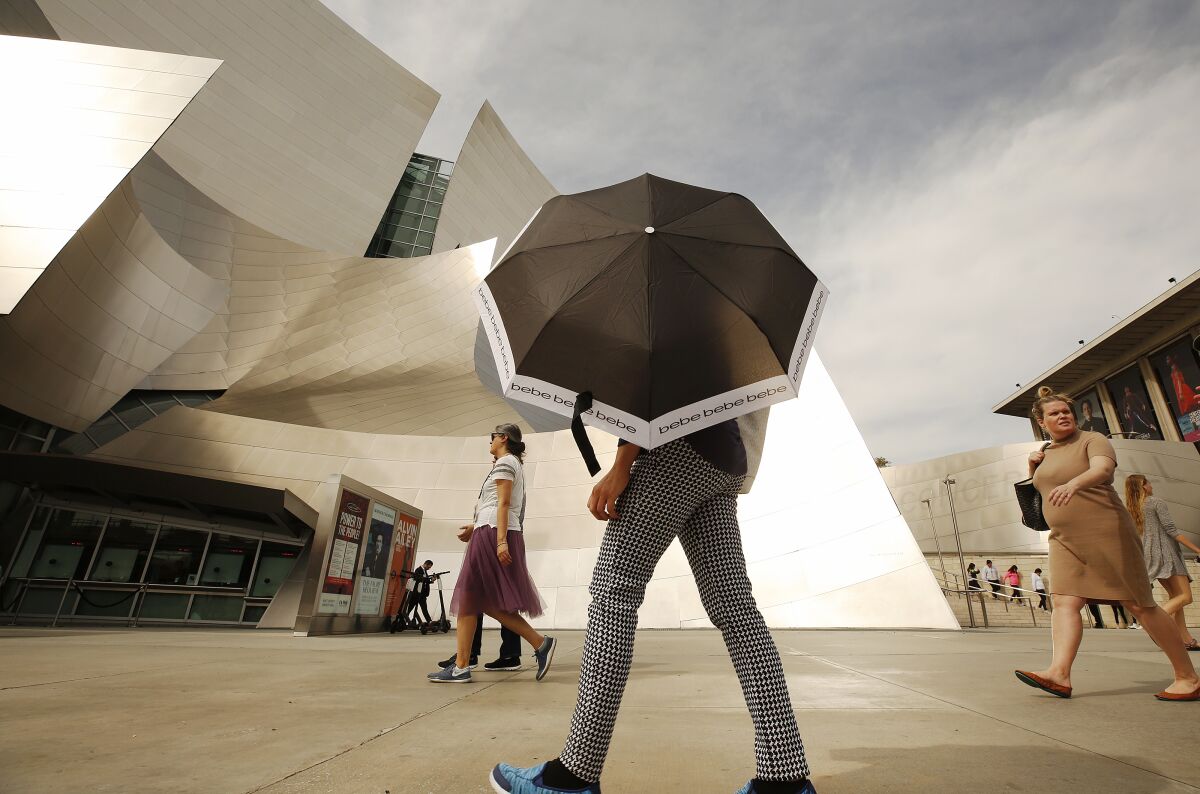 It was sunny and hot enough to need shade protection in downtown Los Angeles on Thursday. Record-setting heat will give way to cooler temperatures and the possibility of showers as a storm system moves over the Los Angeles area this weekend, forecasters say.
