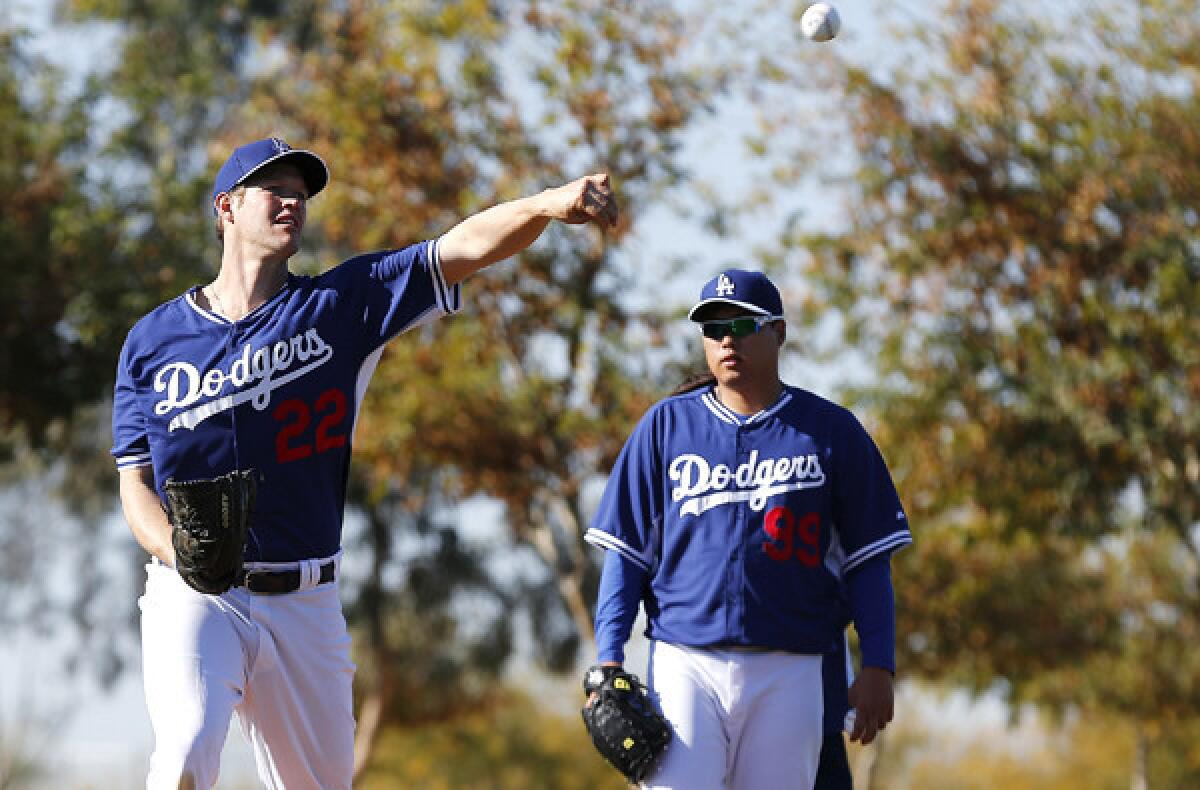 Dodgers ace Clayton Kershaw, left, practices his pick-off move alongside teammate Hyun-Jin Ryu during a spring training workout.