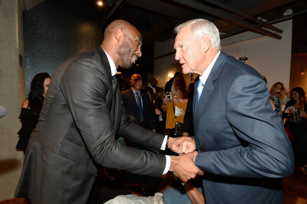 Lakers legends Kobe Bryant and Jerry West greet each other before a game.