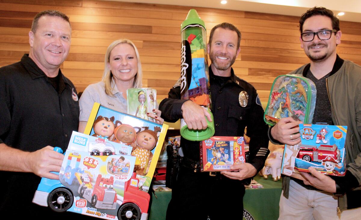 Members of Cops for Kids are, from left, police officer Joe Allen, service officer Amy Tate and Capt. Tim Feeley.  On the far right is Albert Hernandez, president of the Glendale Latino Assn. 