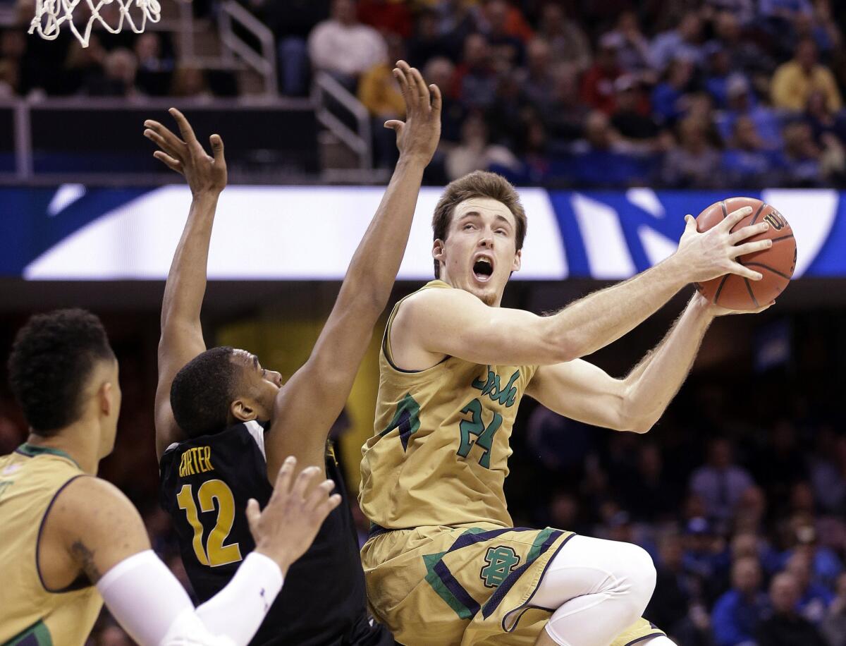 Notre Dame guard Pat Connaughton eleveates for a reverse layup against Wichita State forward Darius Carter in the second half of their Midwest Regional semifinal game Thursday night.