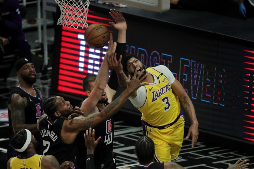 LOS ANGELES, CA - MAY 6, 2021: Los Angeles Lakers forward Anthony Davis (3) tries a reverse lay-up, but runs in to the defense of LA Clippers center Ivica Zubac (40) and LA Clippers forward Kawhi Leonard (2) in the first half at Staples Center on May 6, 2021 in Los Angeles, California.(Gina Ferazzi / Los Angeles Times)