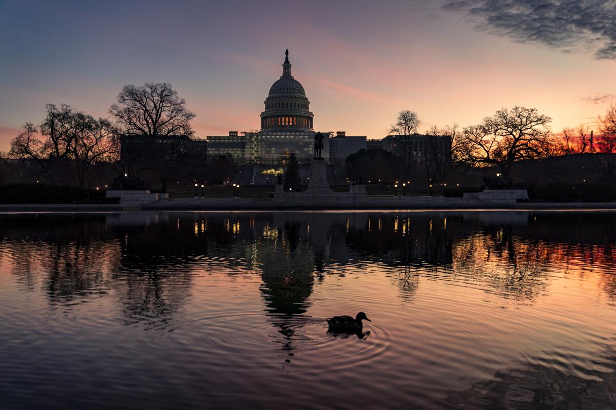 The sun rises behind the Capitol in Washington