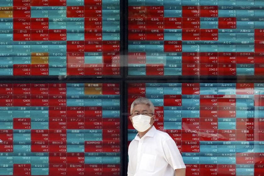 FILE - A person stands in front of an electronic stock board showing Japan's Nikkei 225 index at a securities firm in Tokyo, on Sept. 11, 2023. Asian shares were mostly higher in thin trading Monday, Oct. 2, 2023 with many markets closed for holidays. (AP Photo/Eugene Hoshiko, File)