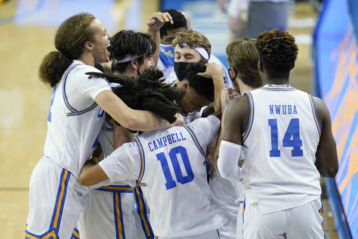UCLA players celebrate after guard Jaylen Clark made a free throw to give the Bruins the lead.