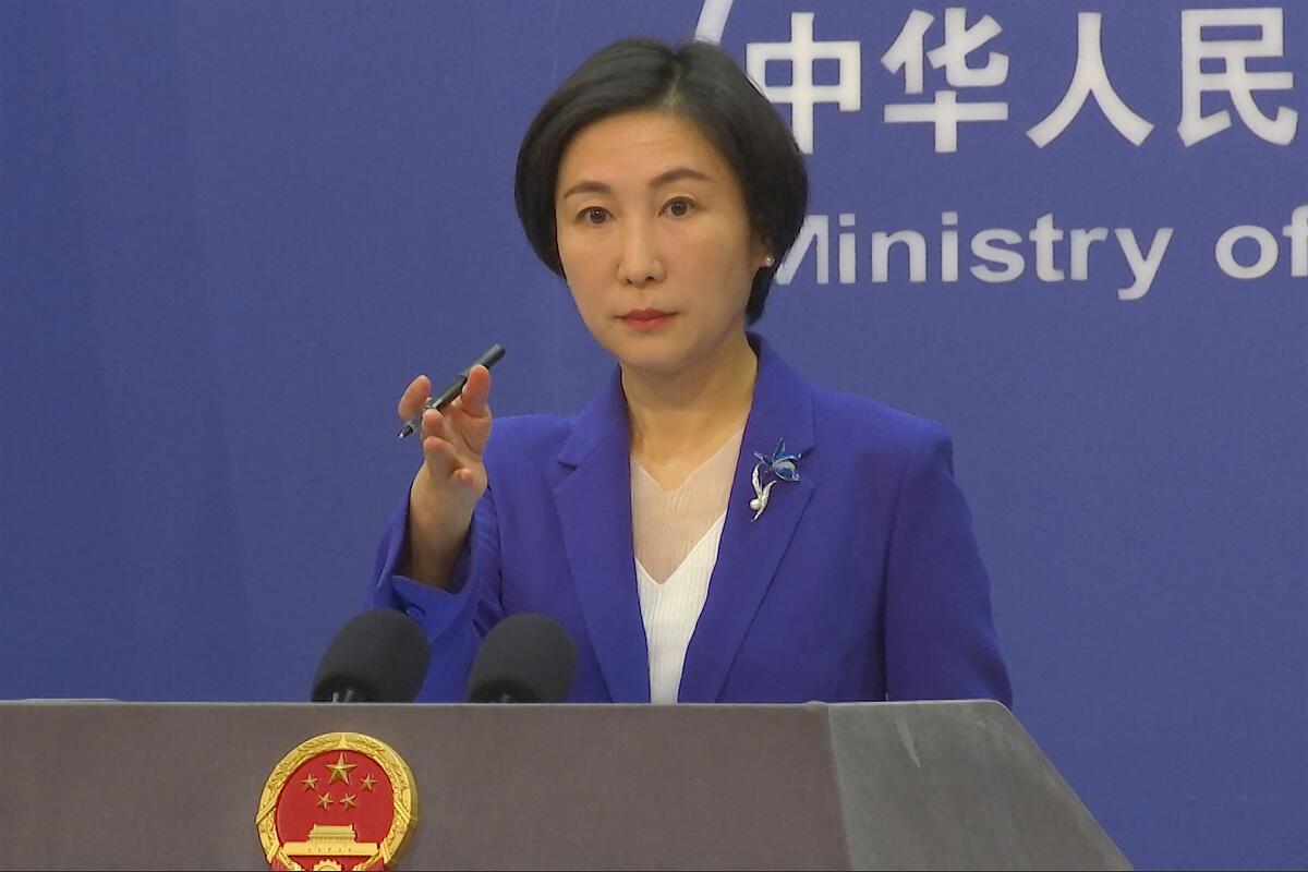 Chinese Foreign Ministry spokeswoman gesturing during a news conference
