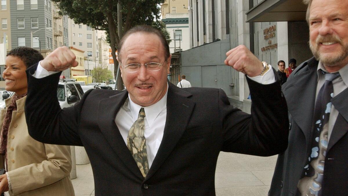 Victor Conte, nutritional adviser and founder of the Bay Area Laboratory Co-Operative (BALCO), flexes his muscles as he leaves a federal courthouse in San Francisco on March 26, 2004.