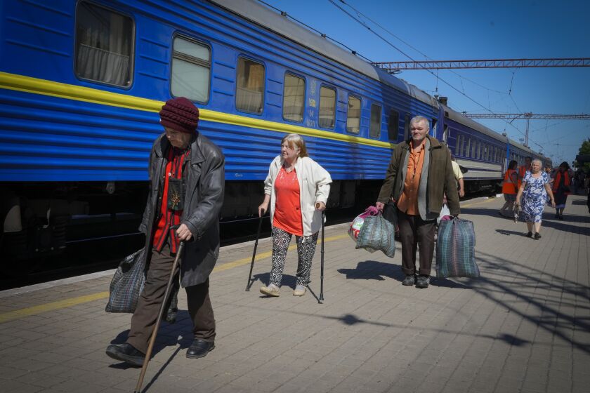 People walk toward the entrance of an evacuation train in Pokrovsk , Ukraine, on Saturday.