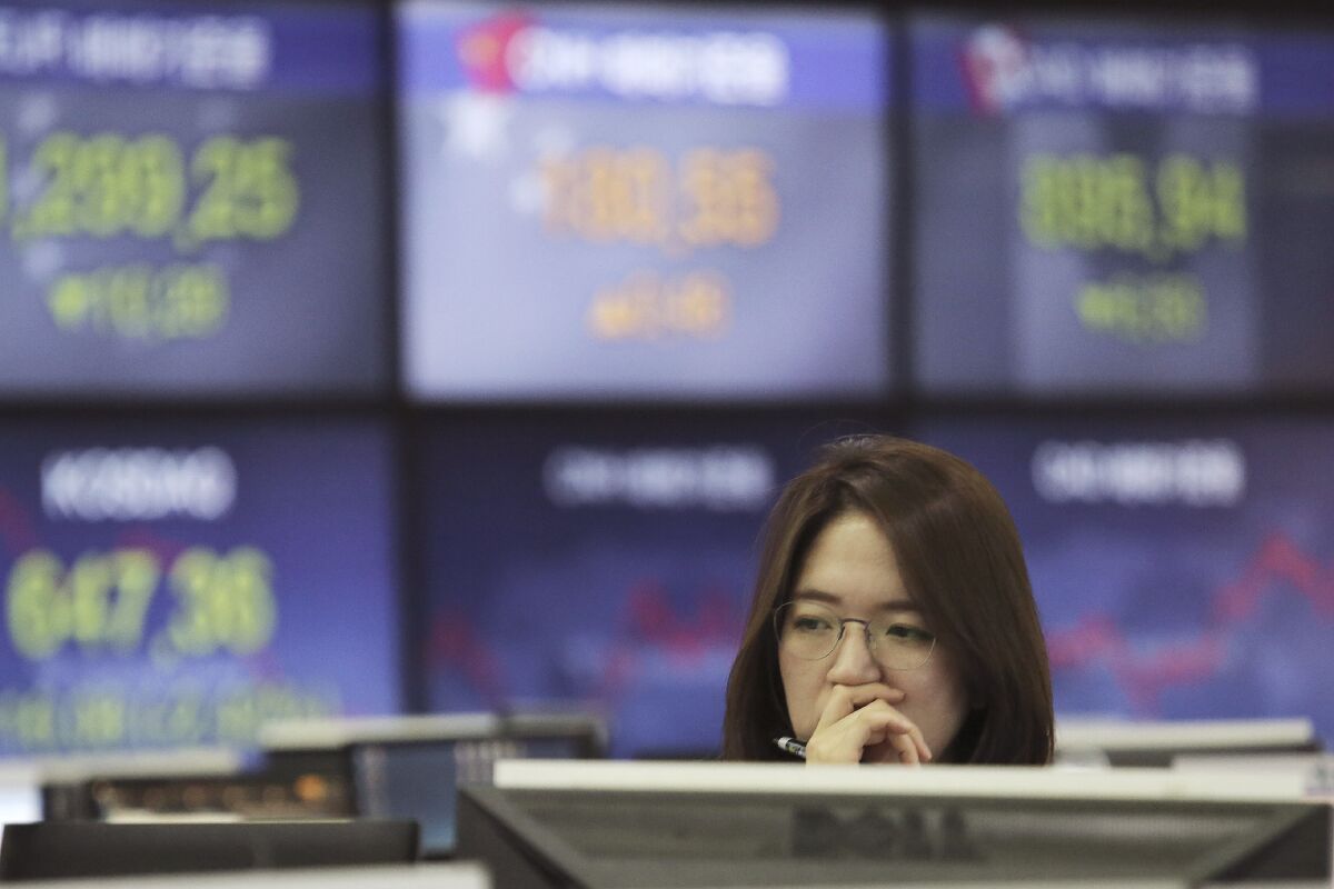 A currency trader watches monitors at the foreign exchange dealing room of the KEB Hana Bank headquarters in Seoul, South Korea on Jan. 8, 2020. Shares were mostly higher in Asia on Monday, Aug. 10, 2020 after President Donald Trump issued executive orders to provide tax relief and stopgap unemployment benefits for Americans hit by the fallout from the coronavirus pandemic. (AP Photo/Ahn Young-joon)