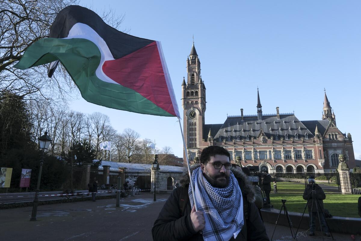 Un manifestante alza una bandera palestina frente al Palacio de la Paz, sede de la Corte Internacional