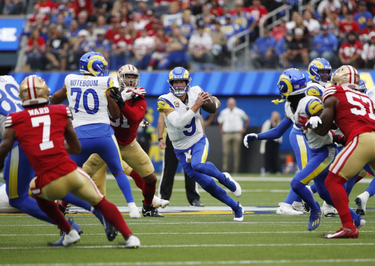 O quarterback do Rams, Matthew Stafford (9), foge do bolso em busca de jardas extras contra o 49ers.