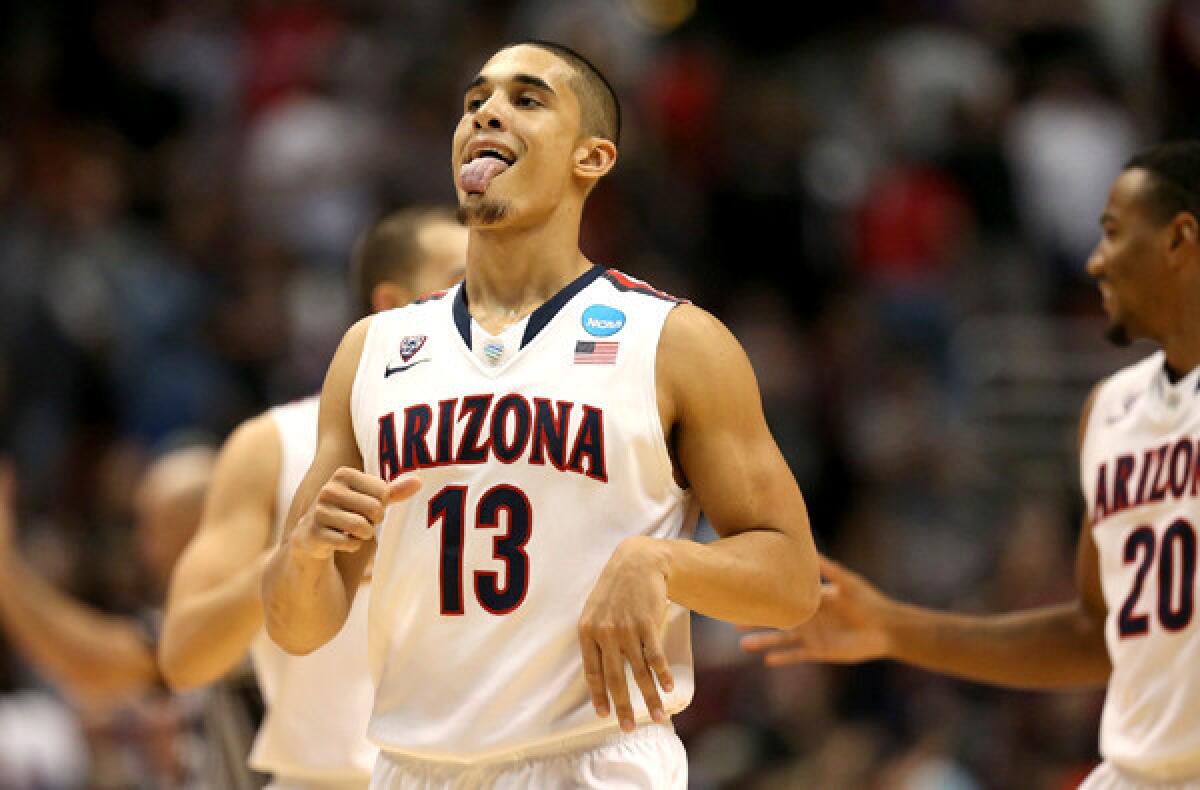 Arizona guard Nick Johnson begins to celebrate after scoring 15 points late against San Diego State in a 70-64 victory in the NCAA tournament West Regional semifinal on Thursday night in Anaheim.