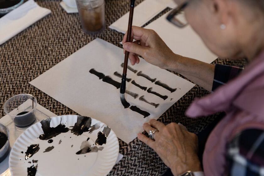 Pam Olivet practices painting bamboo during a traditional Chinese ink painting workshop at ArtReach’s headquarters in San Diego on Saturday, Oct. 15, 2022.