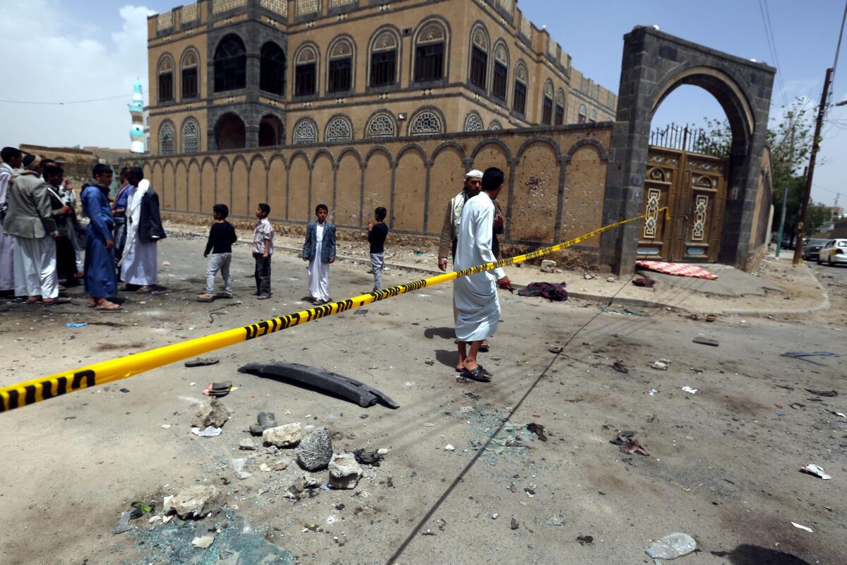 Yemenis and members of the Houthi militia inspect the scene of a suicide attack at a Houthi mosque in Sana'a, Yemen on March 21.