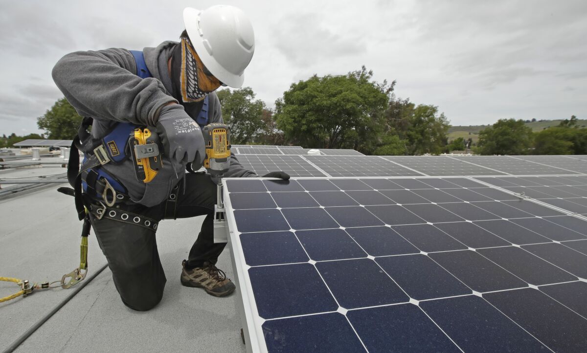 Gen Nashimoto, of Luminalt, installs solar panels in Hayward 