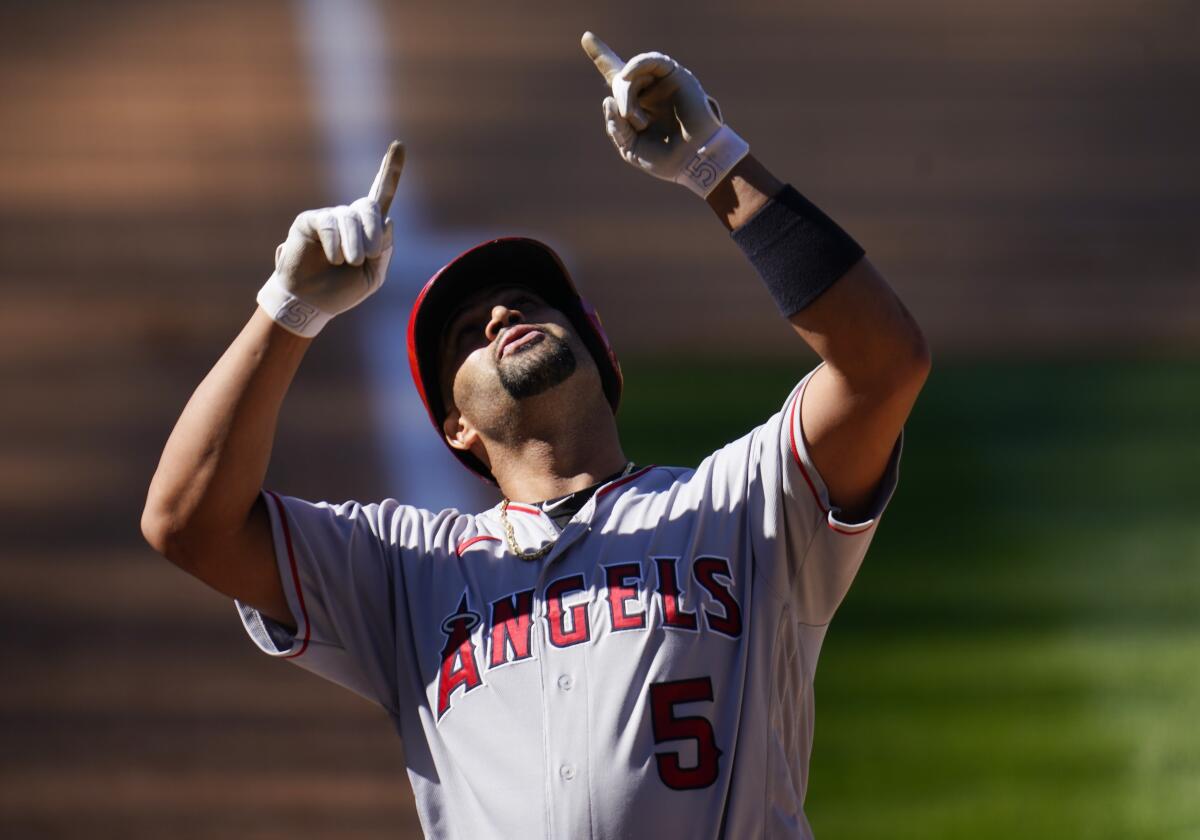 Angels slugger Albert Pujols points skyward as he crosses the plate after hitting a home run.