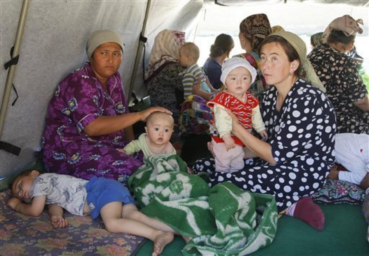 Ethnic Uzbek women and children sit in a tent near Uzbek-Kyrgyz border in outskirts southern city of Osh, Friday, June 18, 2010. The United Nations said as many as 1 million people may need aid in Kyrgyzstan and Uzbekistan, including the potential number of refugees, internally displaced, host families and others that may suffer in one way or another from the unrest. (AP Photo/Sergei Grits)