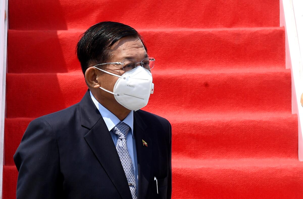 Myanmar Senior Gen. Min Aung Hlaing in mask, at the bottom of red-carpeted stairs