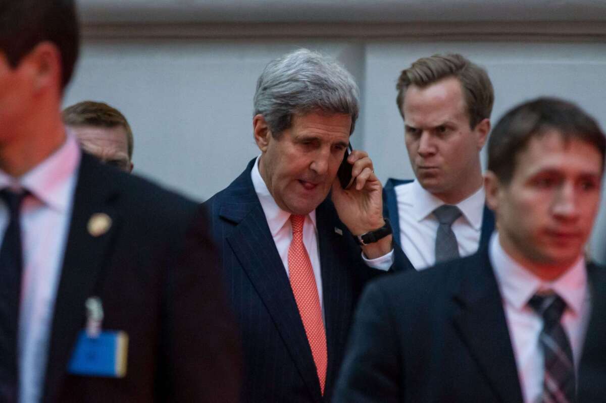 Secretary of State John F. Kerry phones while leaving the Palais Coburg hotel in Vienna.