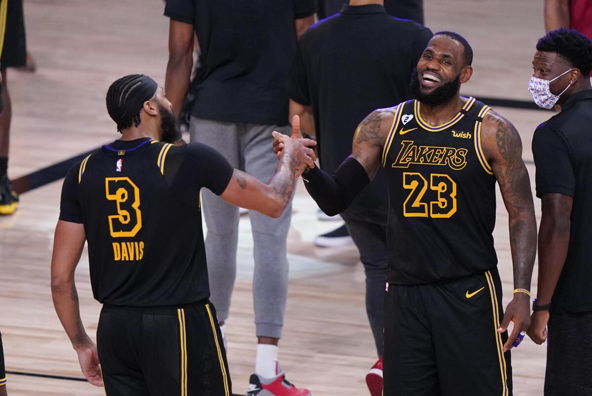 Anthony Davis and LeBron James celebrate after the Lakers beat Denver in Game 2 of their playoff series on Sunday.