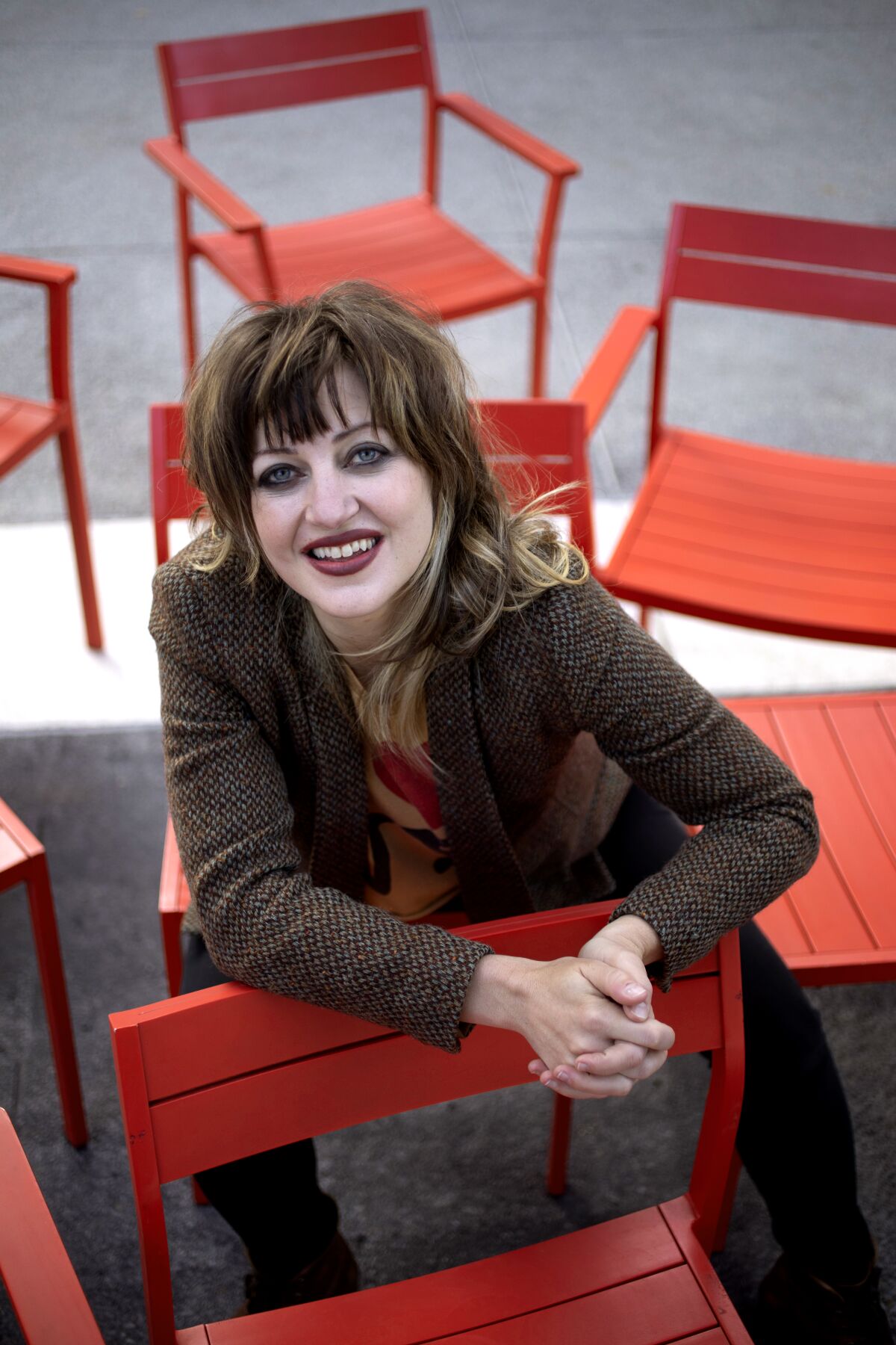 Anaïs Mitchell seated on a red chair.