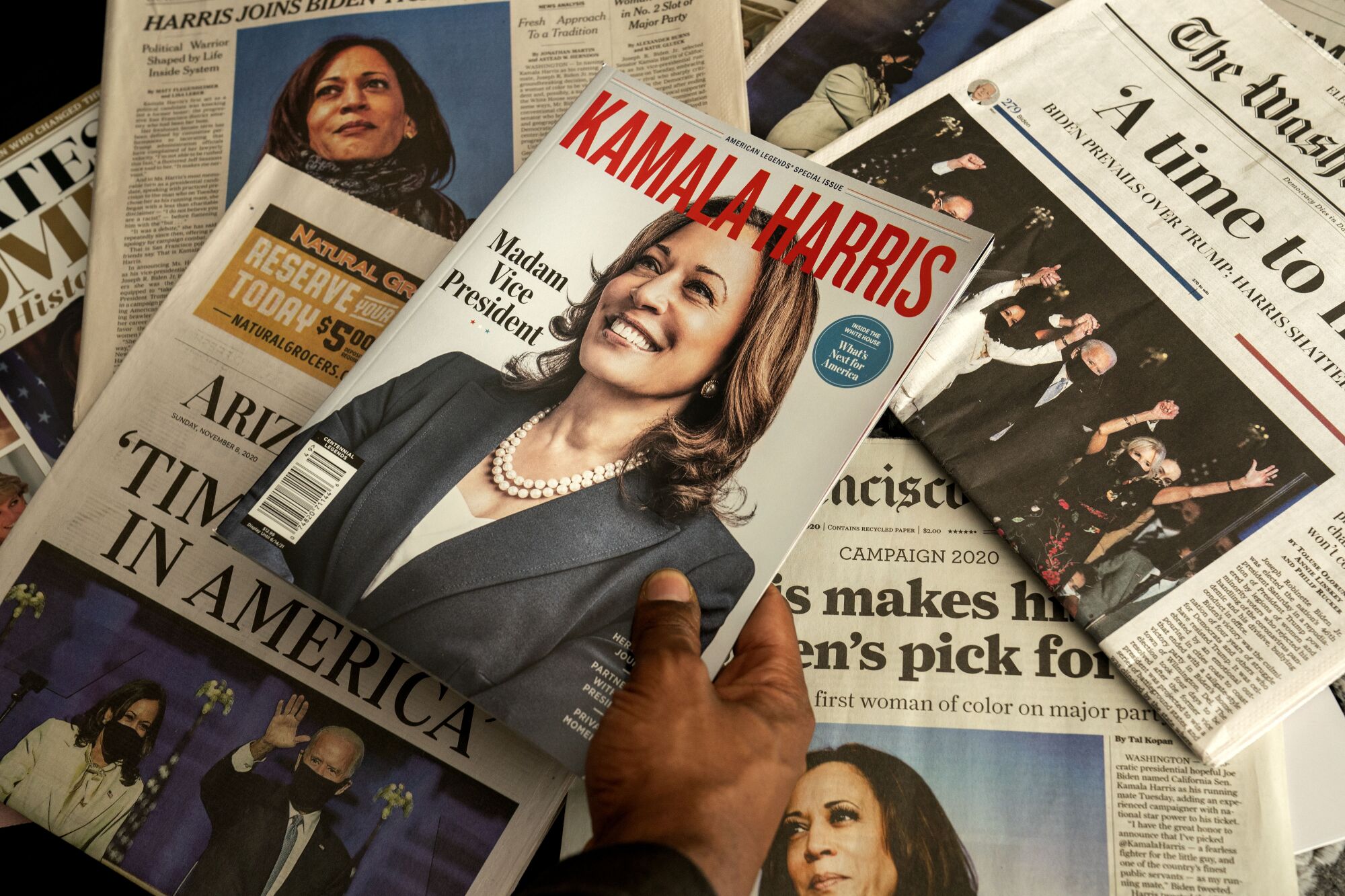 A pile of newspapers and magazines with articles about Kamala Harris. 