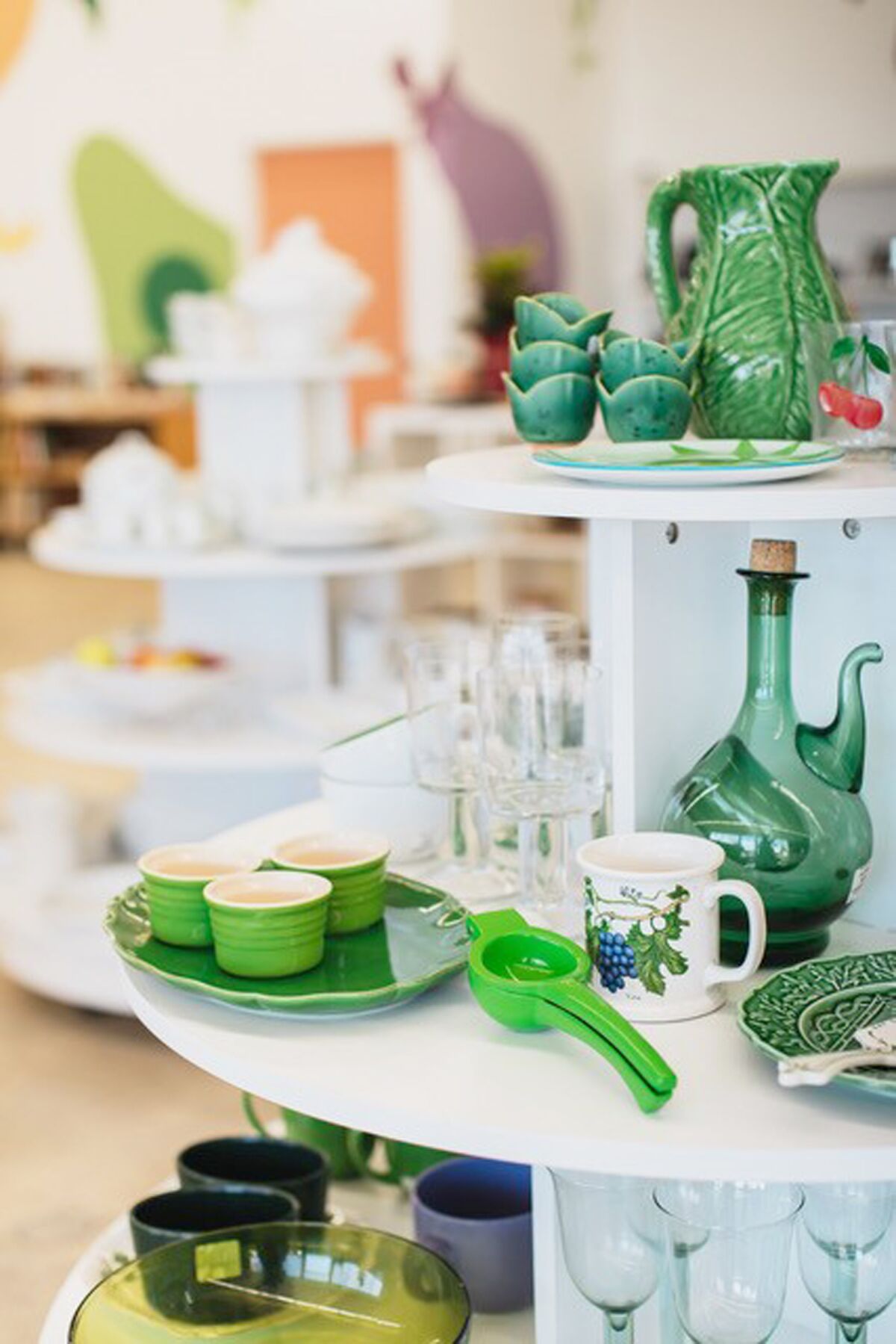 Ceramics, glassware, dinner plates and other green pieces make for a dynamic display on one of the many shop shelves.