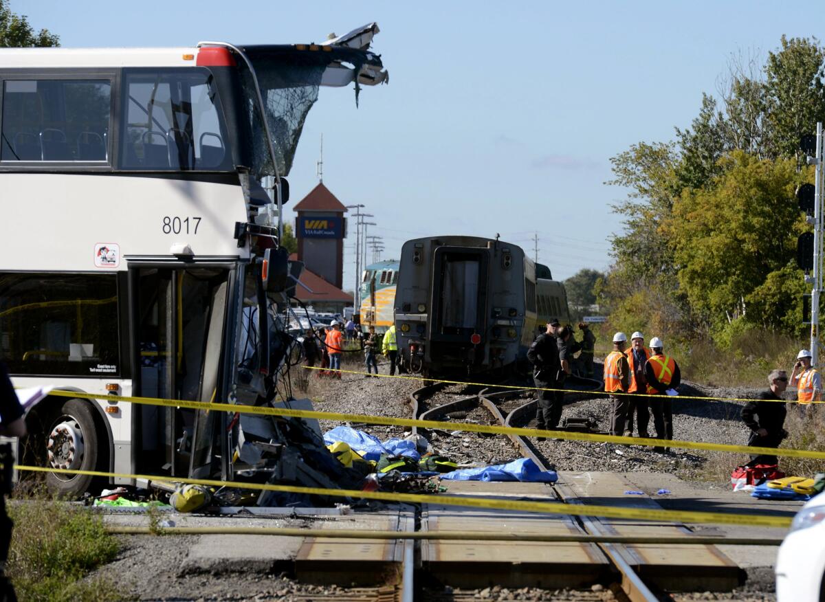 Emergency personnel survey the scene of a collision between a passenger train and a bus in Ottawa, Canada.