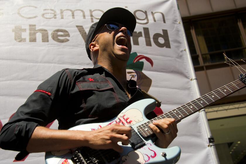 Former Rage Against the Machine guitarist Tom Morello (C) performs at the National Nurses United rally in Chicago, Illinois, May 18, 2012 ahead of the NATO 2012 Summit. Morello told a crowd at a nurses rally in downtown Chicago that someone should" put those NATO criminals in animal cages and crank Rage Against the Machine 24 hours a day." AFP PHOTO/Jim Watson (Photo credit should read JIM WATSON/AFP/GettyImages)