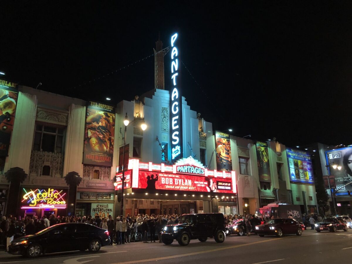 The Pantages Theatre marquee, advertising Bob Dylan, and blade sign lit up at night.