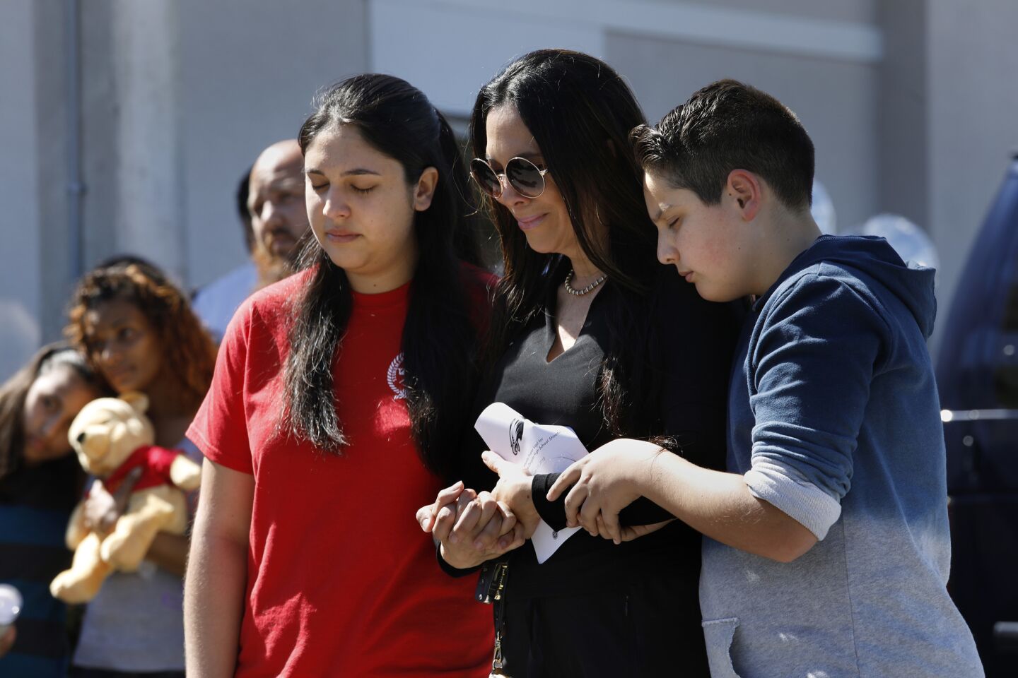 Antonina Messina, 17, a student at Marjorie Stonemason Douglas High School, left, attends a vigil with her mother Clara Messina, center, and brothter, Matteo Messina, right.