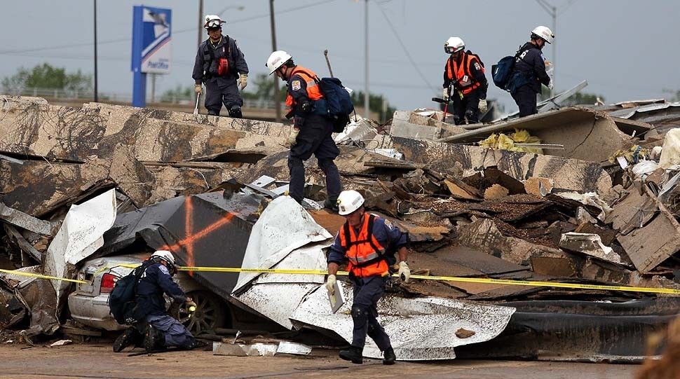 Members of Nebraska Task Force 1 search a destroyed building the day after a tornado hit in Moore, Okla.