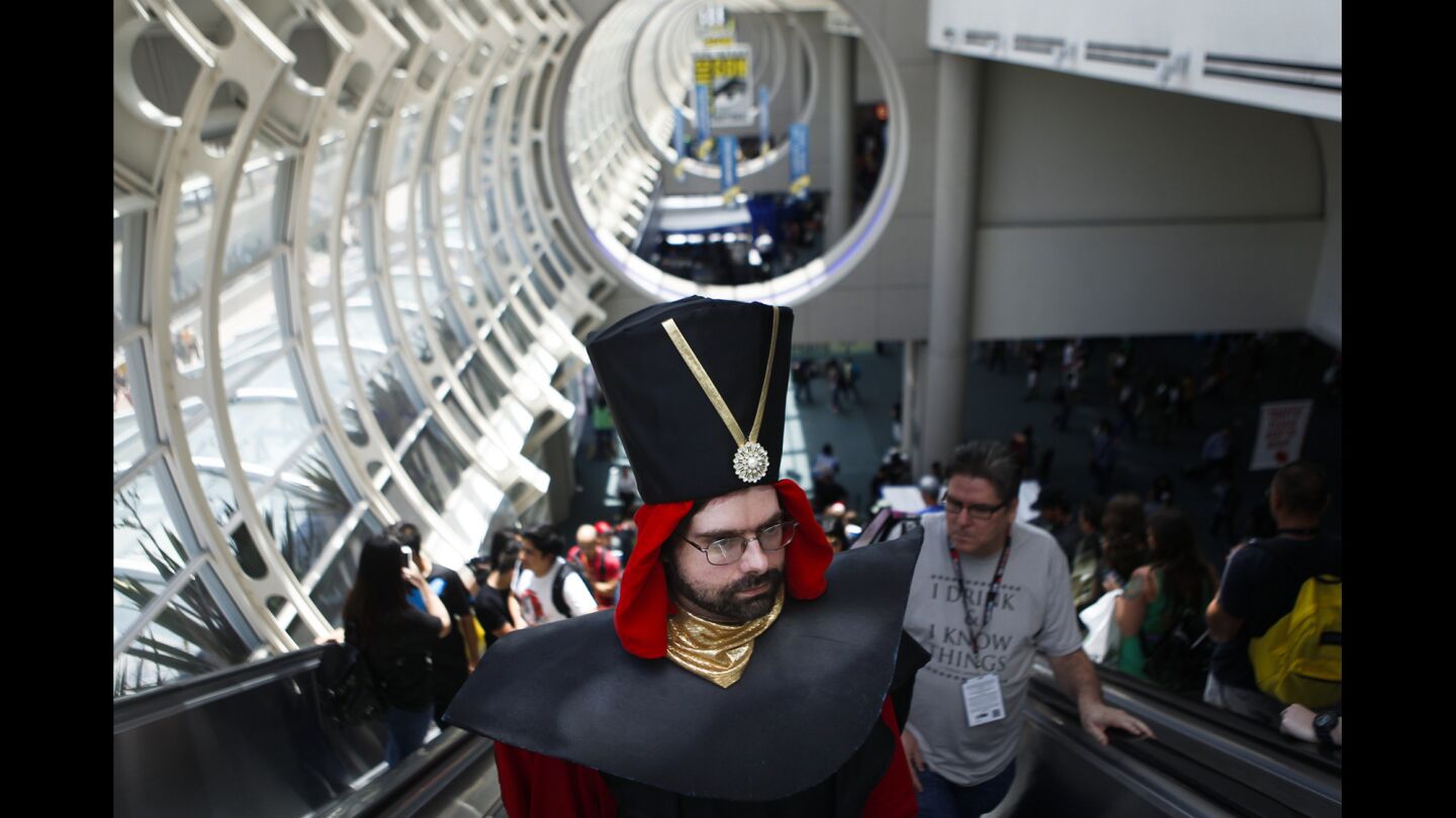 Philip Brown, center, heads to the second floor of the San Diego Convention Center during the first day of the Comic-Con International convention. Brown was dressed as Jafar from "Aladdin."