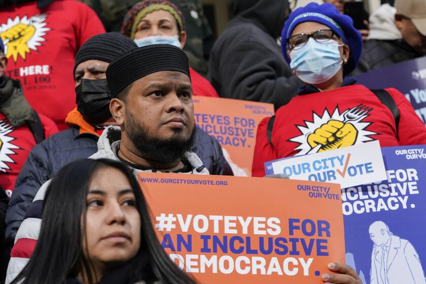 Activists participate in a rally on the steps of City Hall ahead of a City Council vote to allow lawful permanent residents to cast votes in elections to pick the mayor, City Council members and other municipal officeholders, Thursday, Dec. 9, 2021, in New York. (AP Photo/Mary Altaffer)