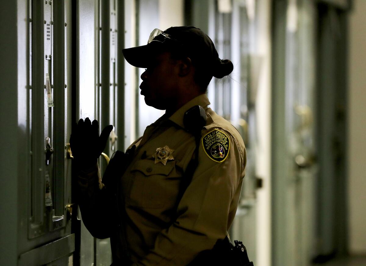 A prison guard checks on inmates at California State Prison, Sacramento. 