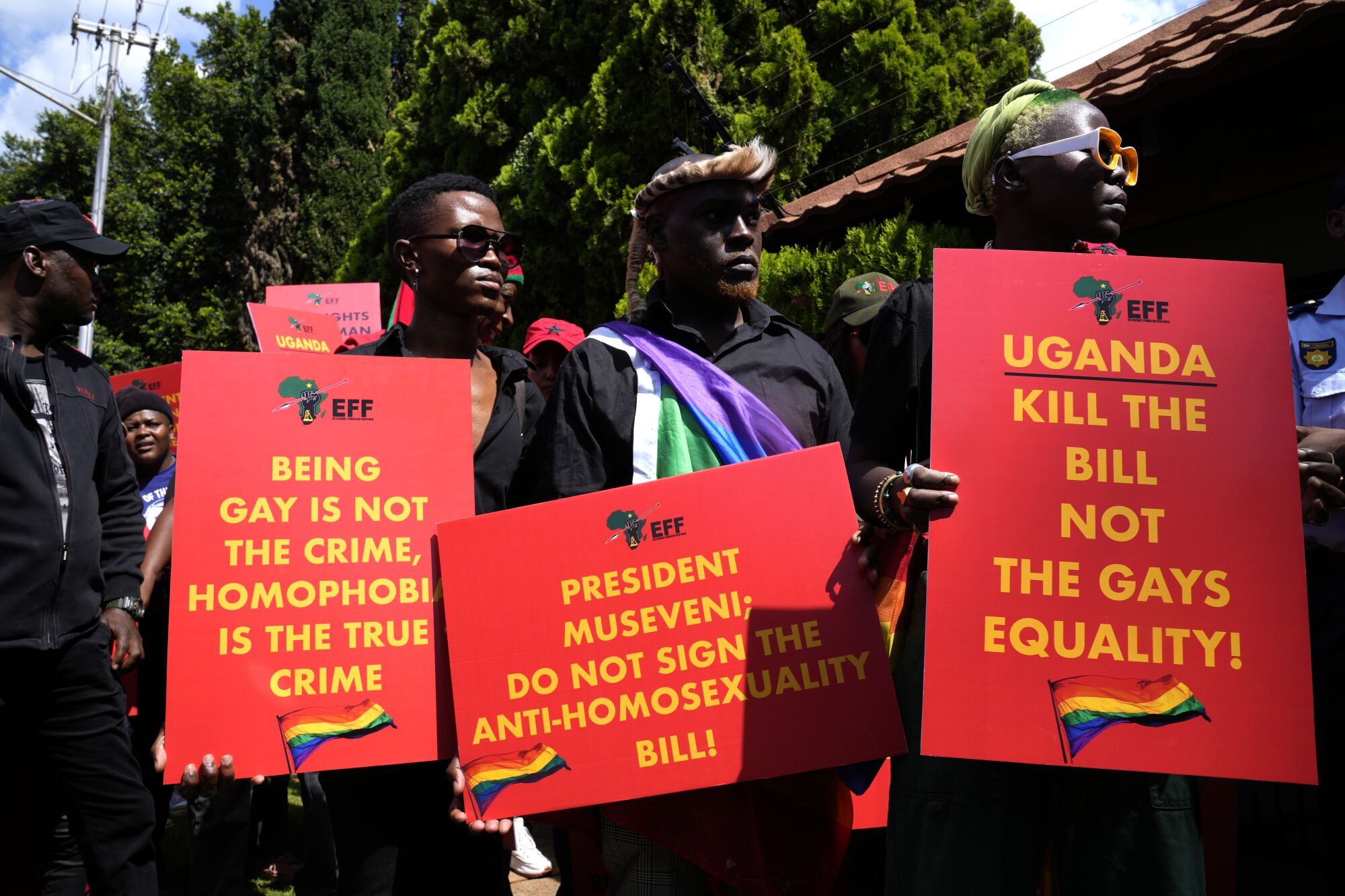 Aktivistler, LGBTQ karşıtı yasa tasarısına karşı bir mitingde pankartlar taşıyor 