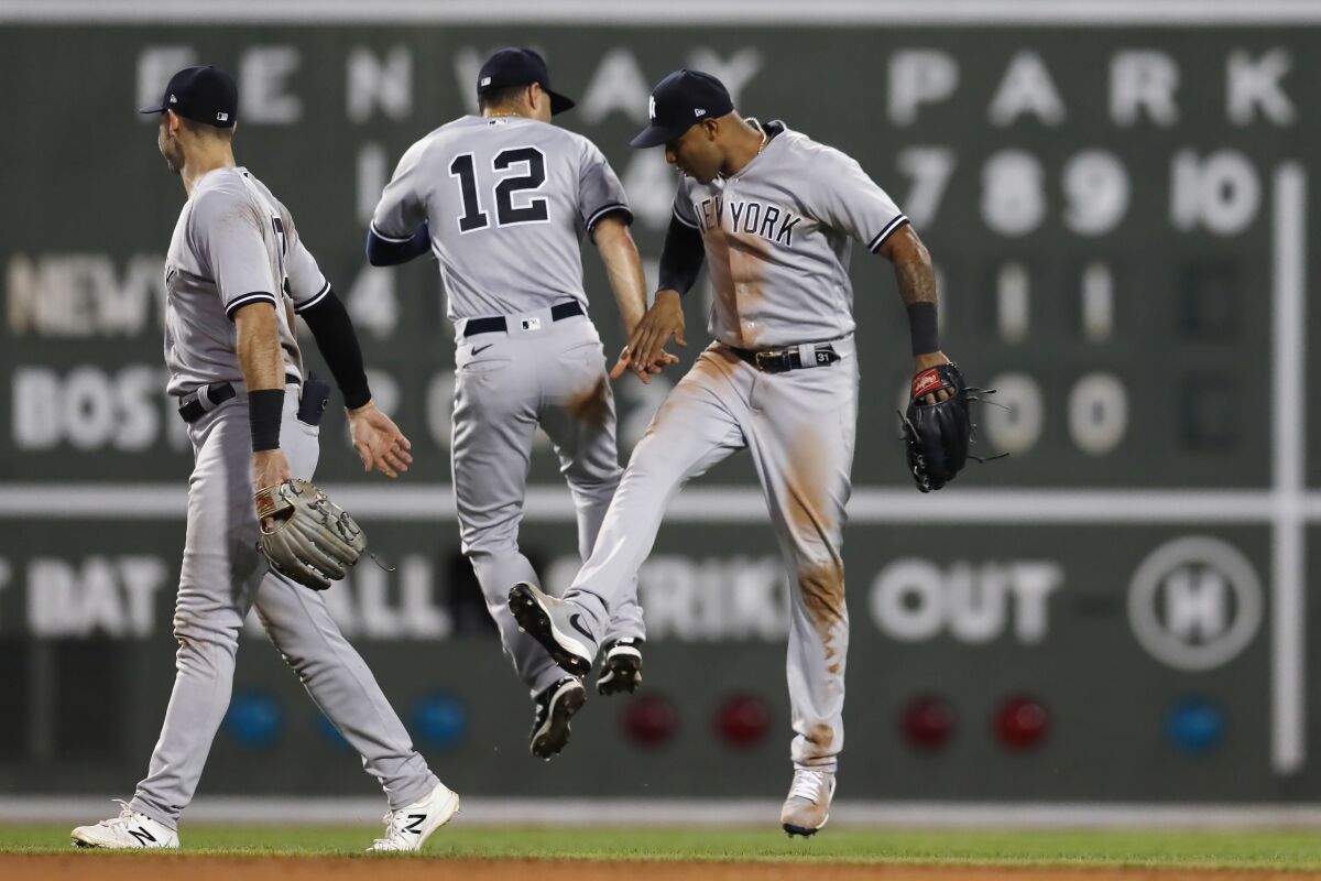 New York Yankees' Isiah Kiner-Falefa (12) and Aaron Hicks, right, celebrate after the team's win over the Boston Red Sox in a baseball game, Friday, July 8, 2022, in Boston. (AP Photo/Michael Dwyer)