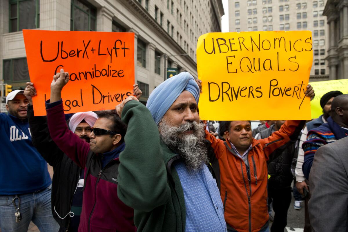 Ubernomics: Who benefits? Taxi and Uber drivers protest the ride-hailing services Uber X and Lyft last month in Philadelphia.