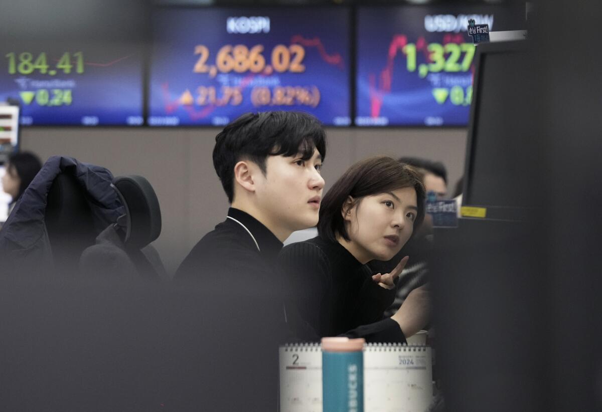 Currency traders watch monitors at KEB Hana Bank headquarters in Seoul