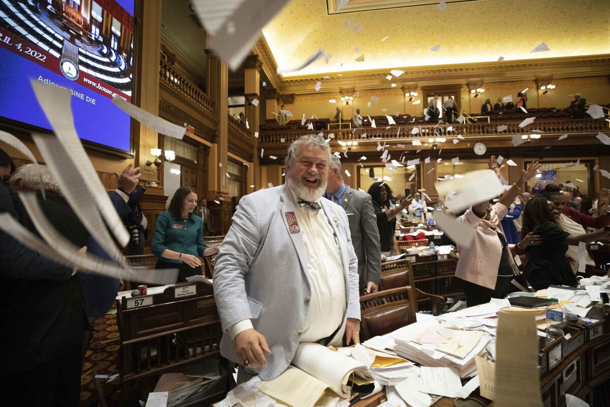 House members throw up paper at the conclusion of the legislative session in the House Chamber on Sine Die, the last day of the General Assembly at the Georgia State Capitol in Atlanta on Tuesday, April 5, 2022. (Branden Camp/Atlanta Journal-Constitution via AP)