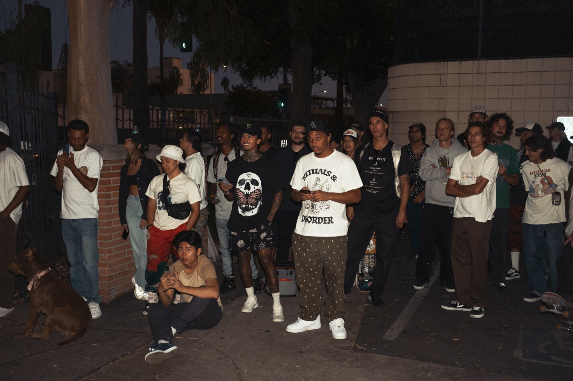 As day turns to night at Hollywood High, an even bigger crowd — including Nyjah Huston, center — gathers for Domo Walker.