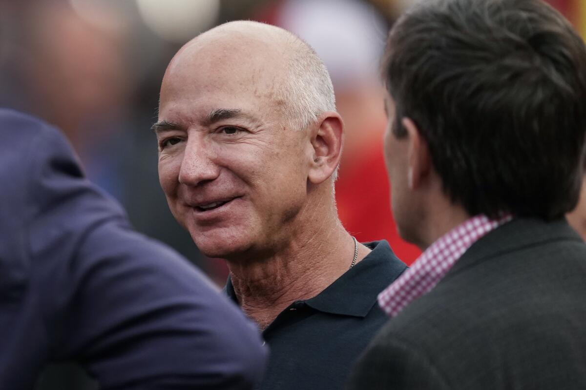 Jeff Bezos, fundador de Amazon, conversa antes del inicio de un partido de la NFL
