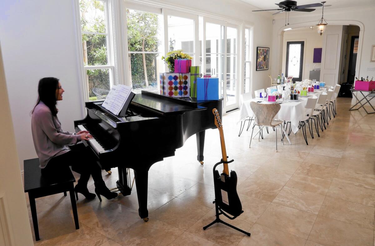 Jayne Flinn plays piano in what she and her husband call their "transitional dining room" in their Newport Beach home. It's a multi-purpose solarium/music room that can become a dining space when needed -- folding tables, linens and more are kept in a closet.