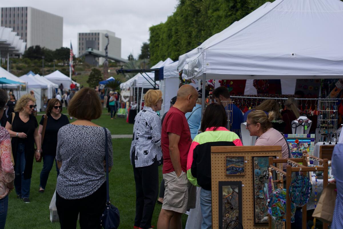 Visitors to the 2022 Art in the Park event speak with one of the vendors.