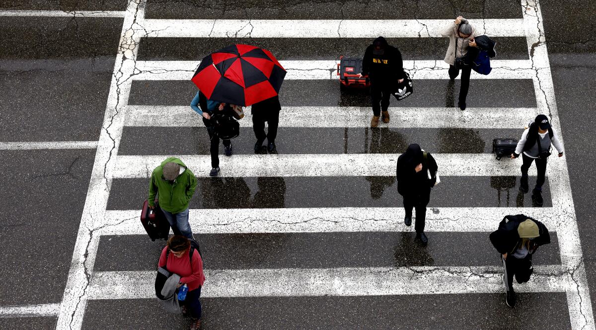 People in a crosswalk in the rain.